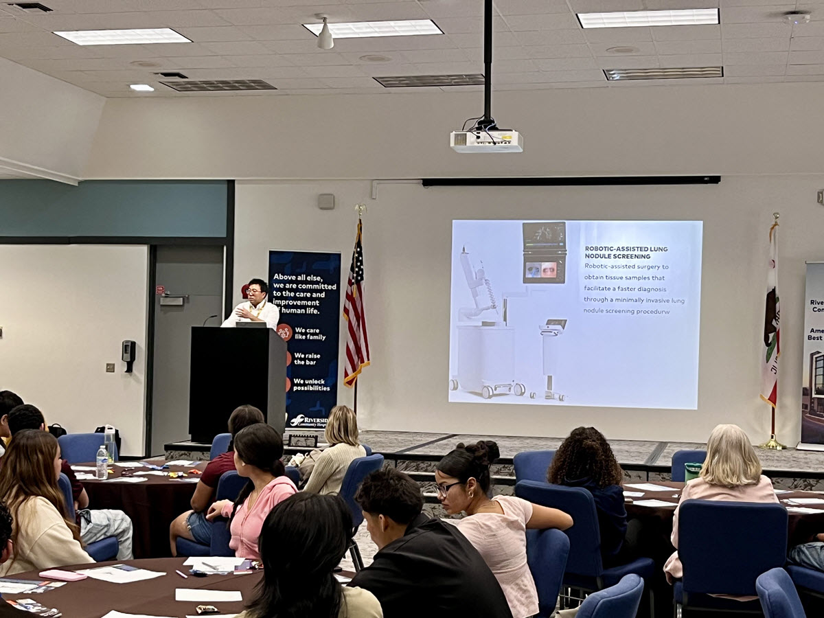 Dr. Aaron Lee presents to the students about robotics.