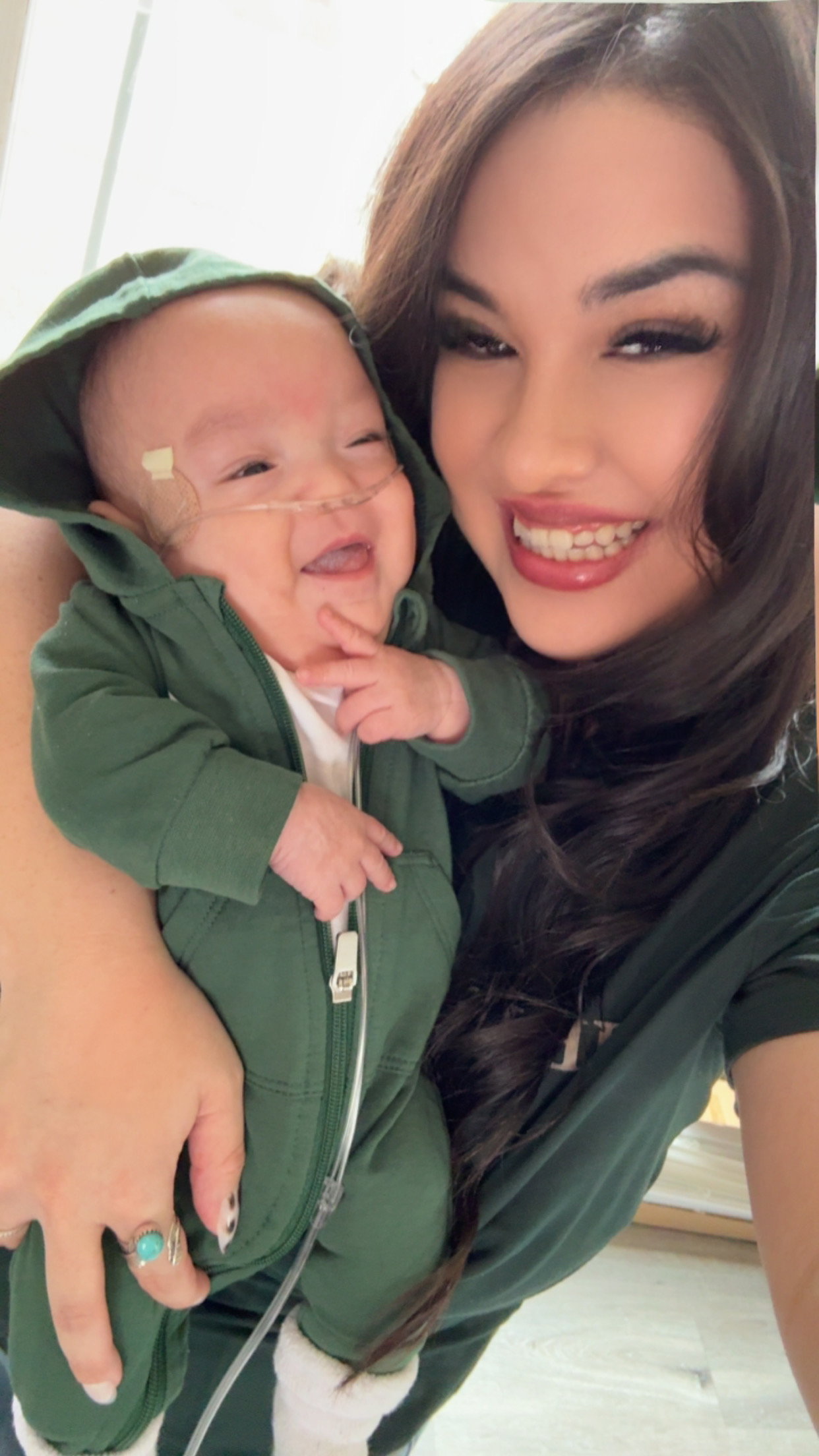 A women smiling holding her newborn baby.