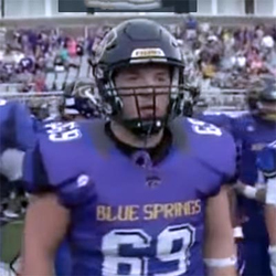 Spencer Johnson wearing a football helmet and shoulder pads during a football game.