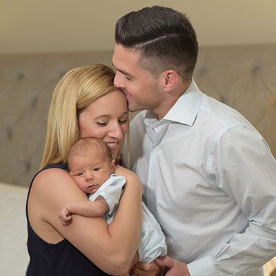 Mother Chrissie holding her son and embraced by her husband