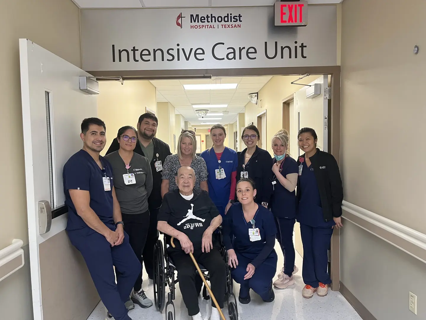 Danielo Tiongsong in a wheelchair leaving the Intensive Care Unit, posing with ICU and Methodist Healthcare staff.