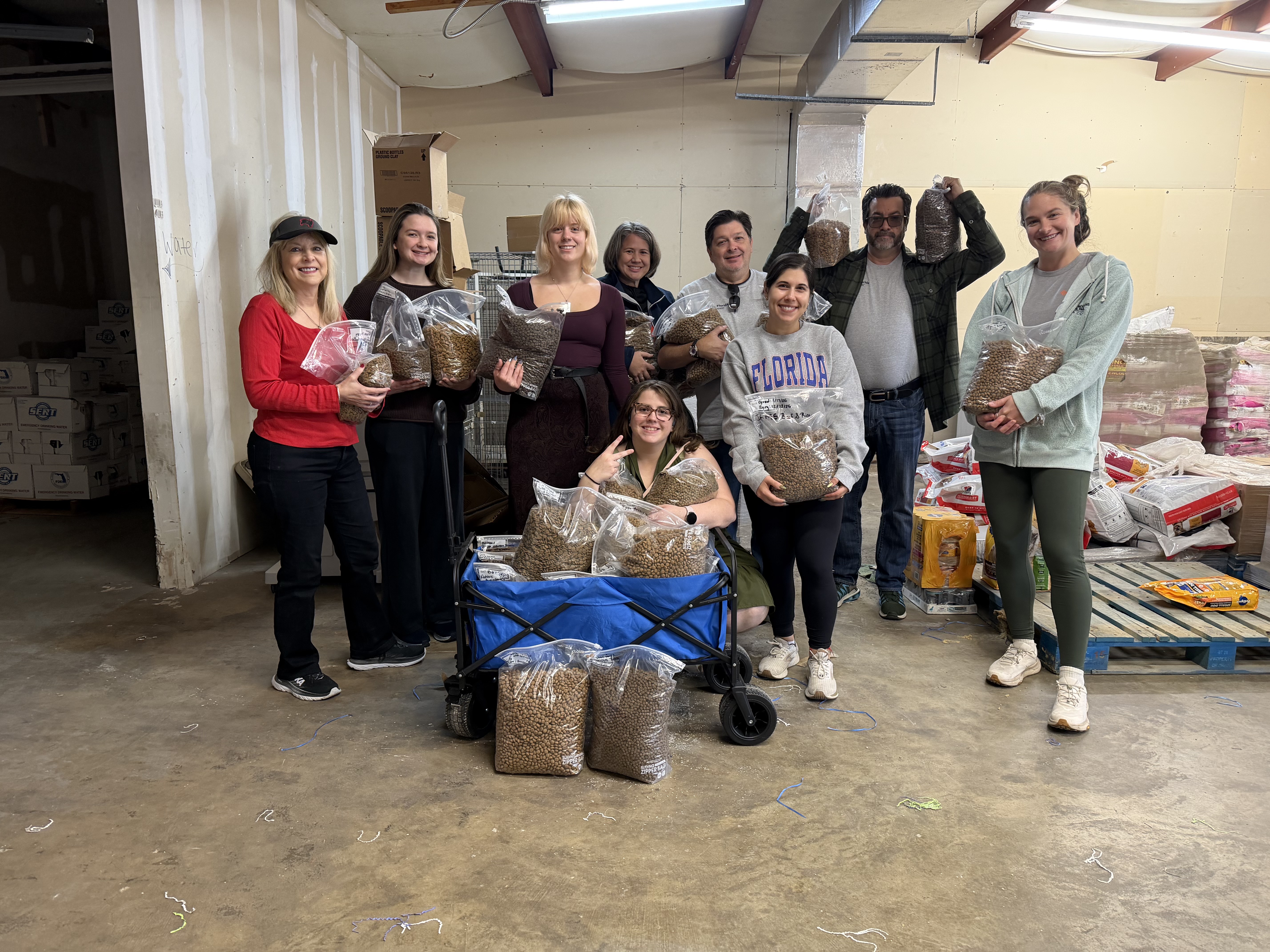 HCA employees take group photo and pose with bags of animal food while supporting Friends of Strays.