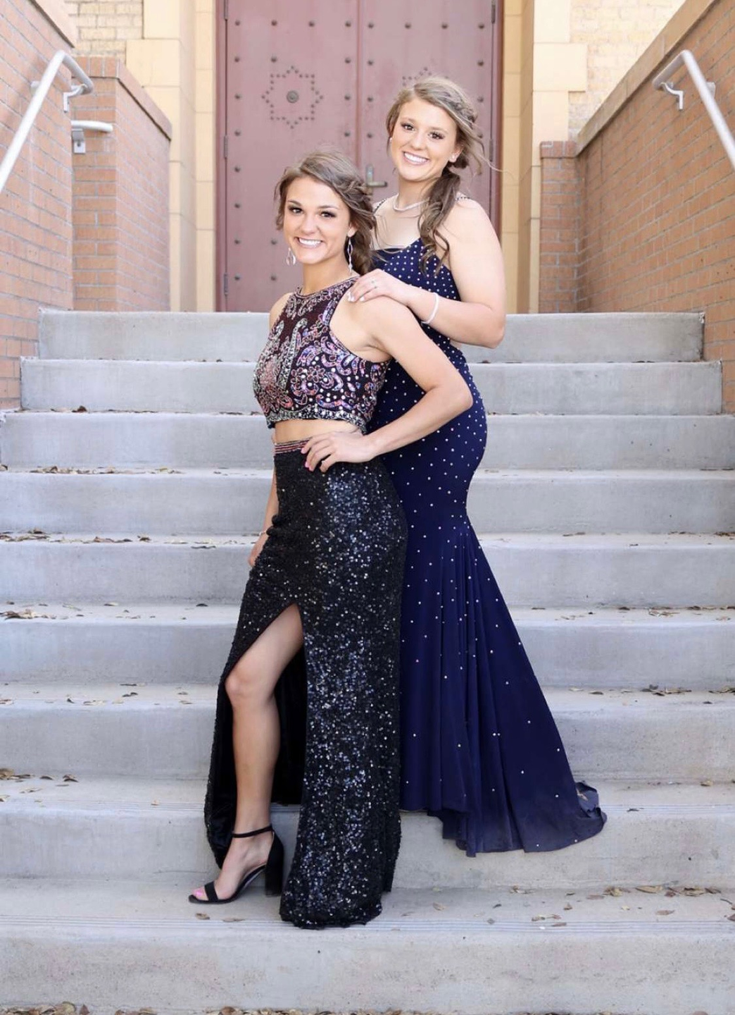 Brynn and Madison Rodgers posing for a photo with their prom dresses.