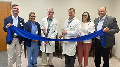 Members of Colleton Medical Center cutting a giant ribbon to commemorate the relocation of Coastal Carolina Surgical Specialists.