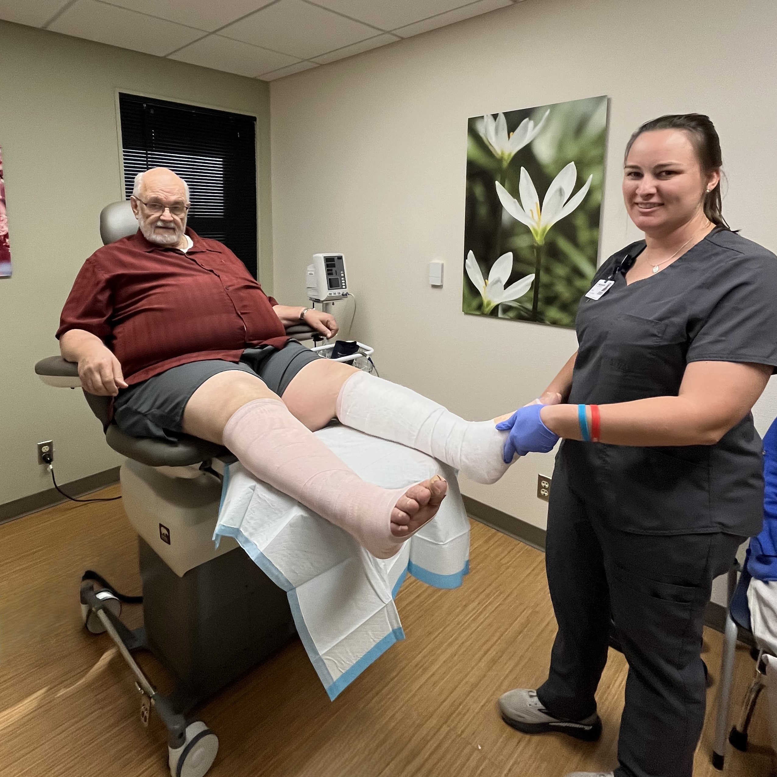 Patrick Klein having legs bandanged by nurse.