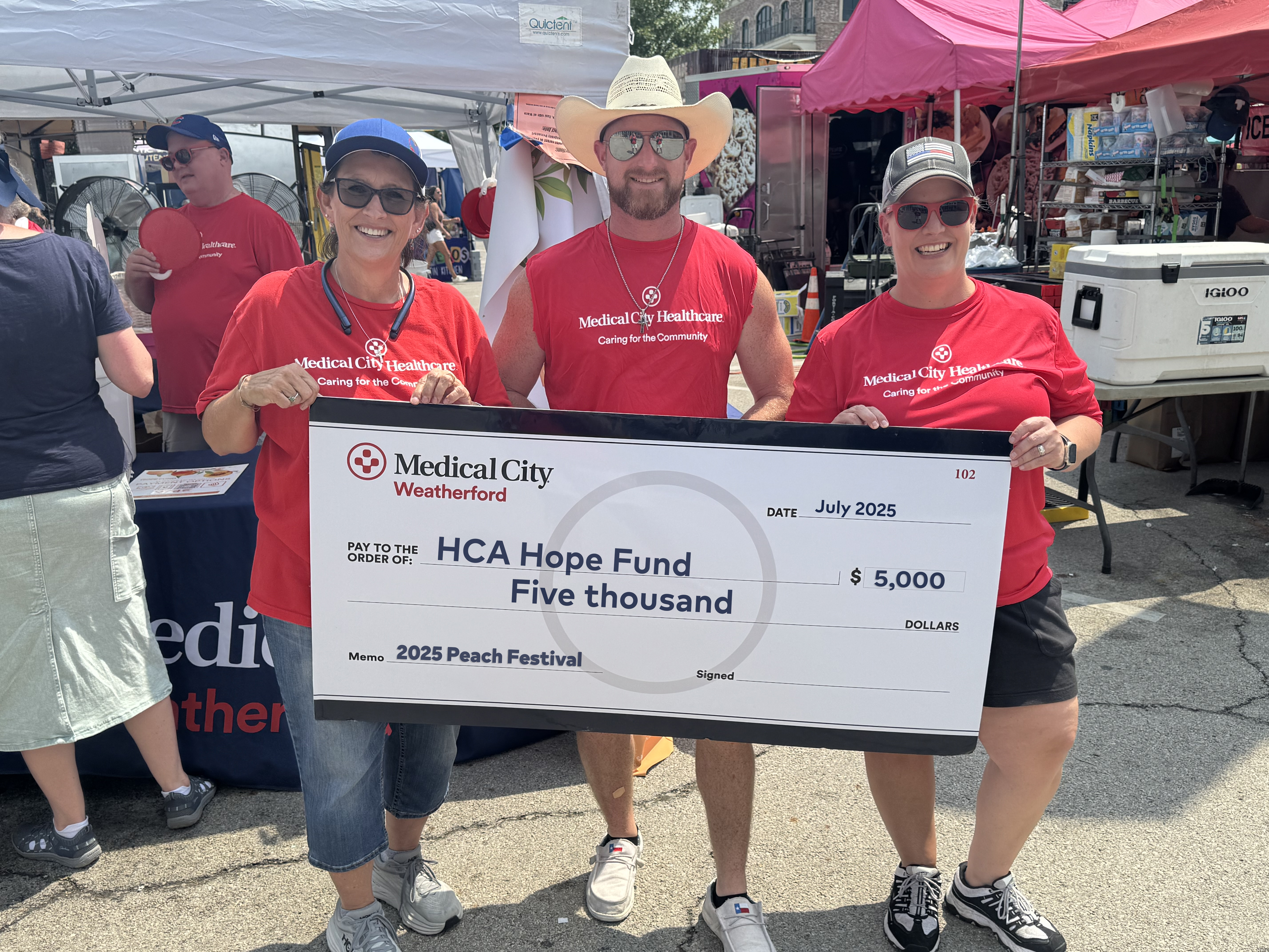  Team holding a $5,000 check at the 2025 Parker County Peach Festival