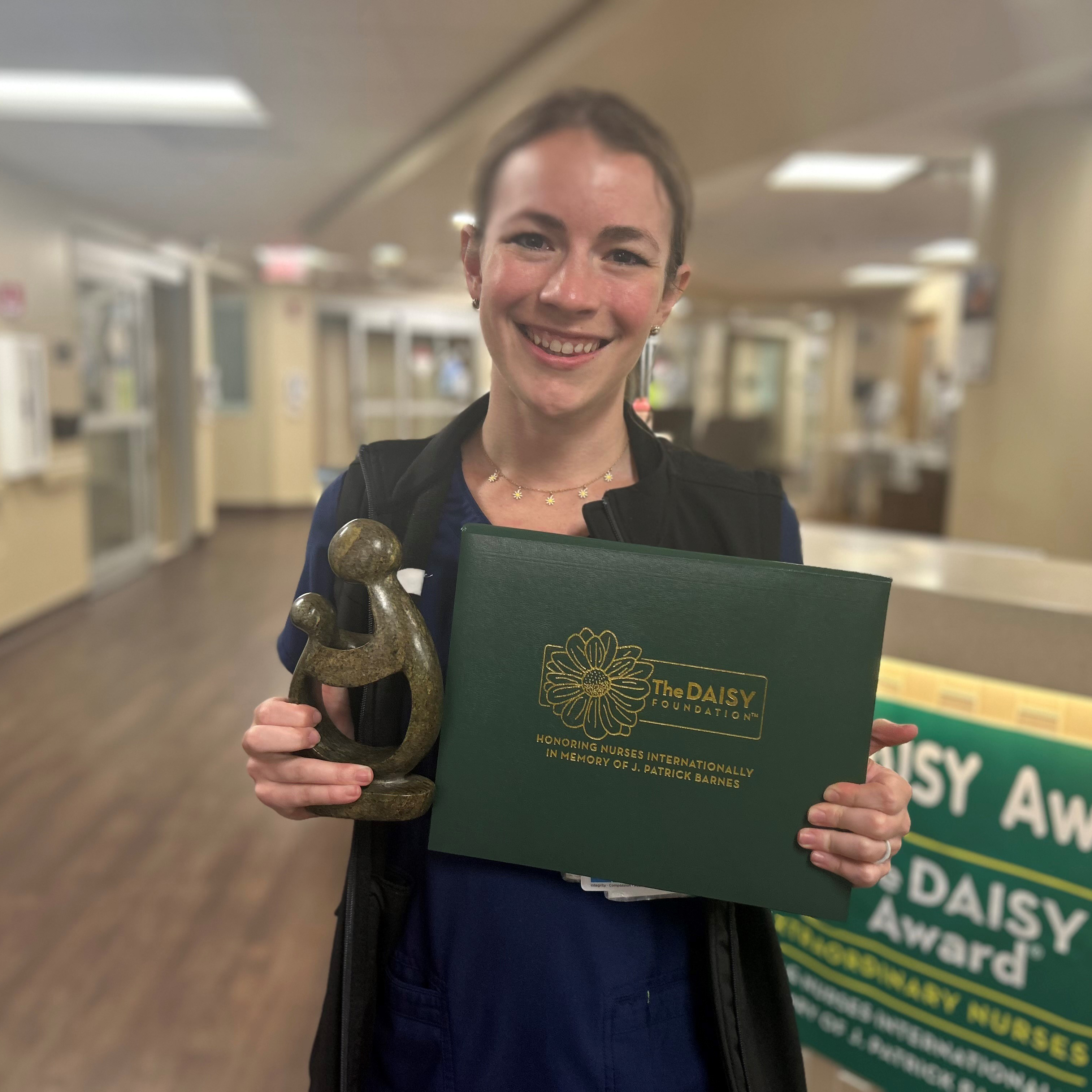 June 2025 Daisy Winner - Natalie Mathay holding statue 