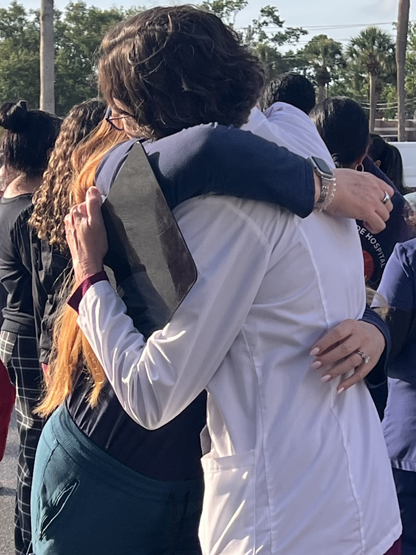 Two more people embrace at the celebration nurse Tara McClintock's life.