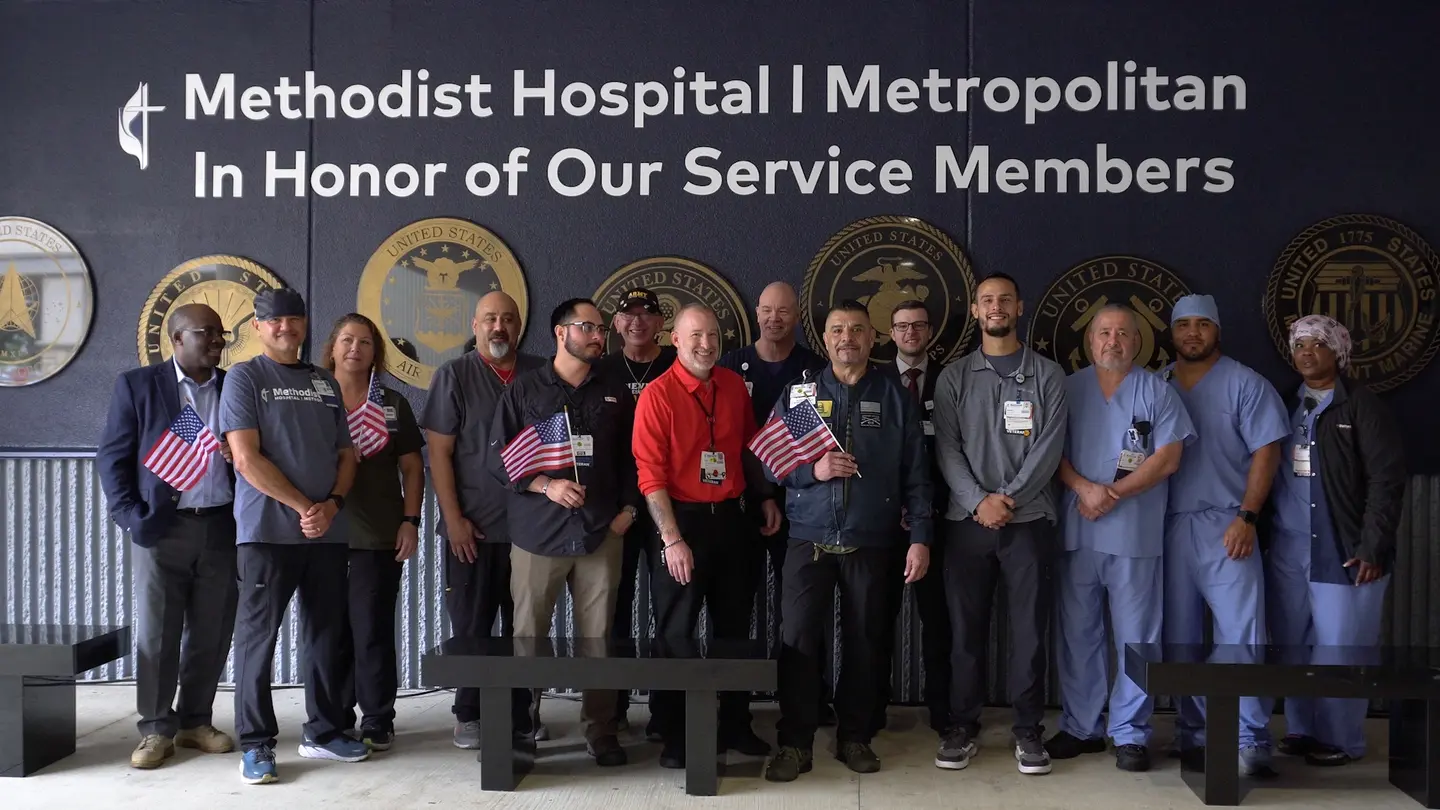 Methodist Hospital Metropolitan unveils Tribute Wall to Veterans outside of the hospital with a group of people.