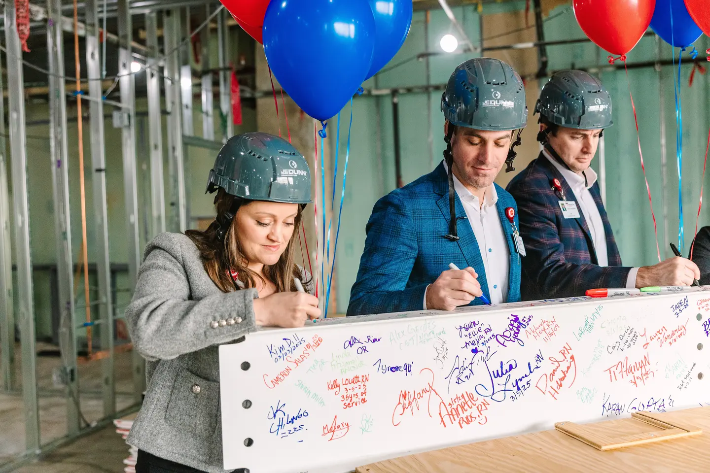 Photo of team signing beam.