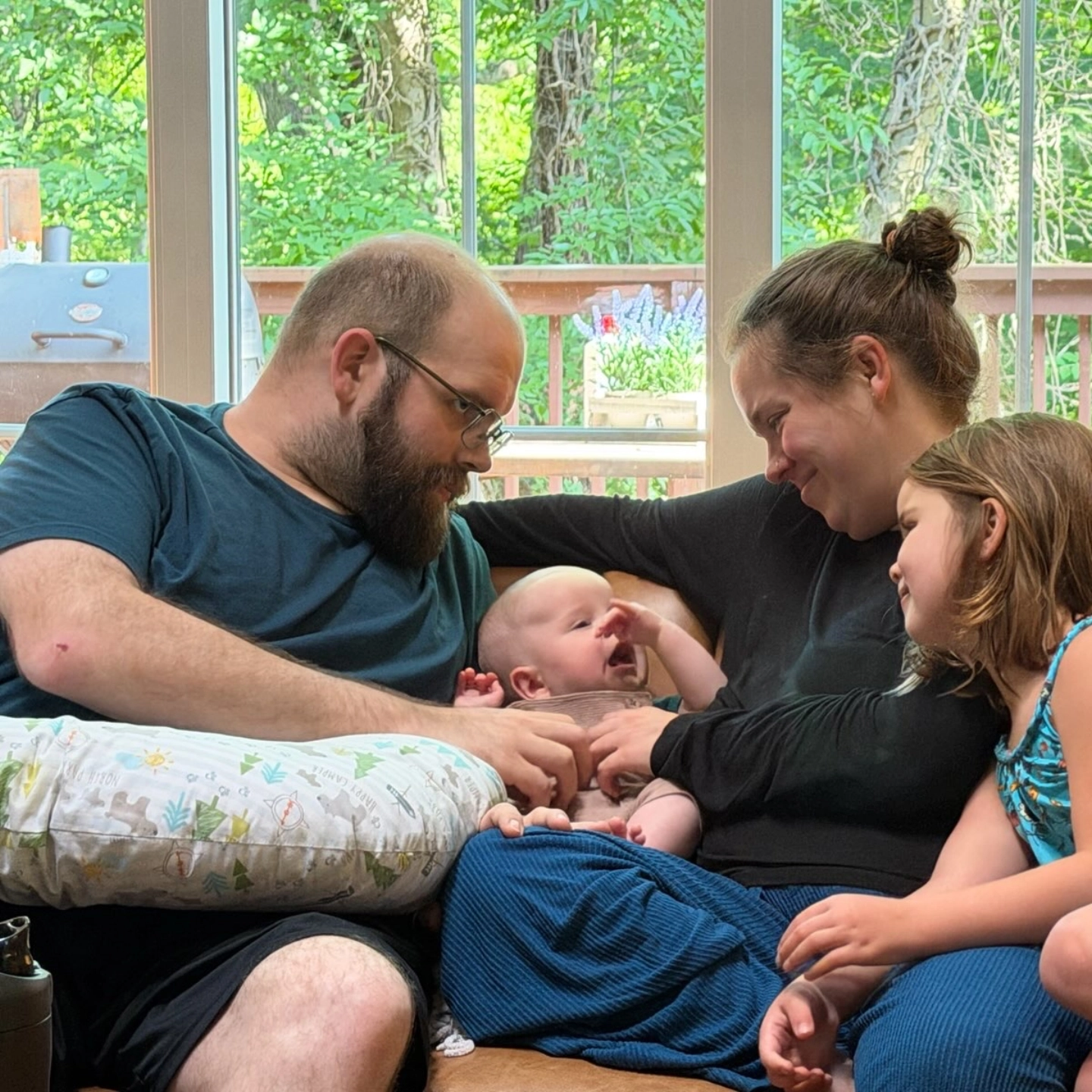 Matthew and Miranda Flowers recline with their children on a couch.