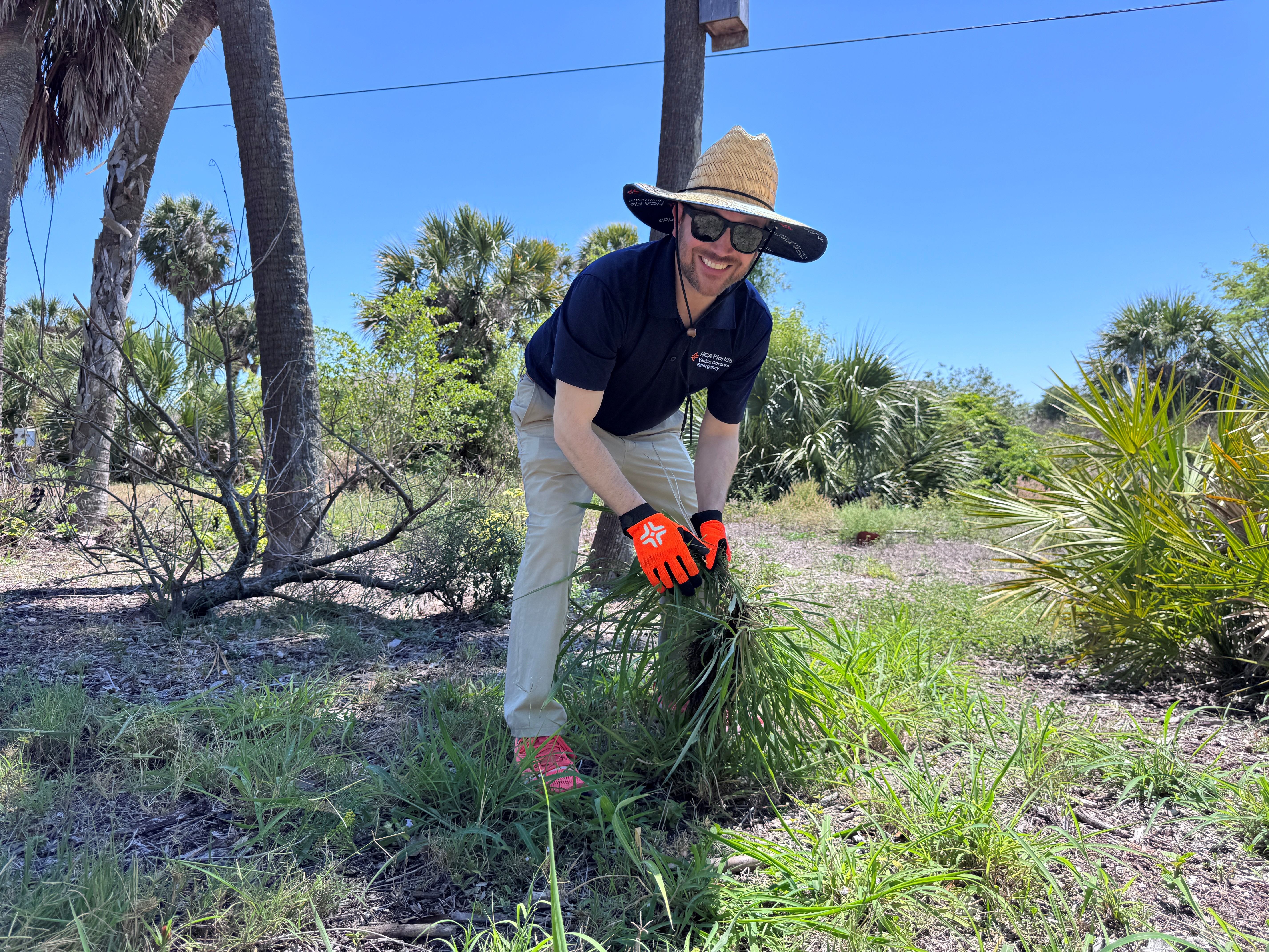 Sarasota Doctors Hospital CEO Joe Rudisill removes overgrowth during a community cleanup project in the Venice area.