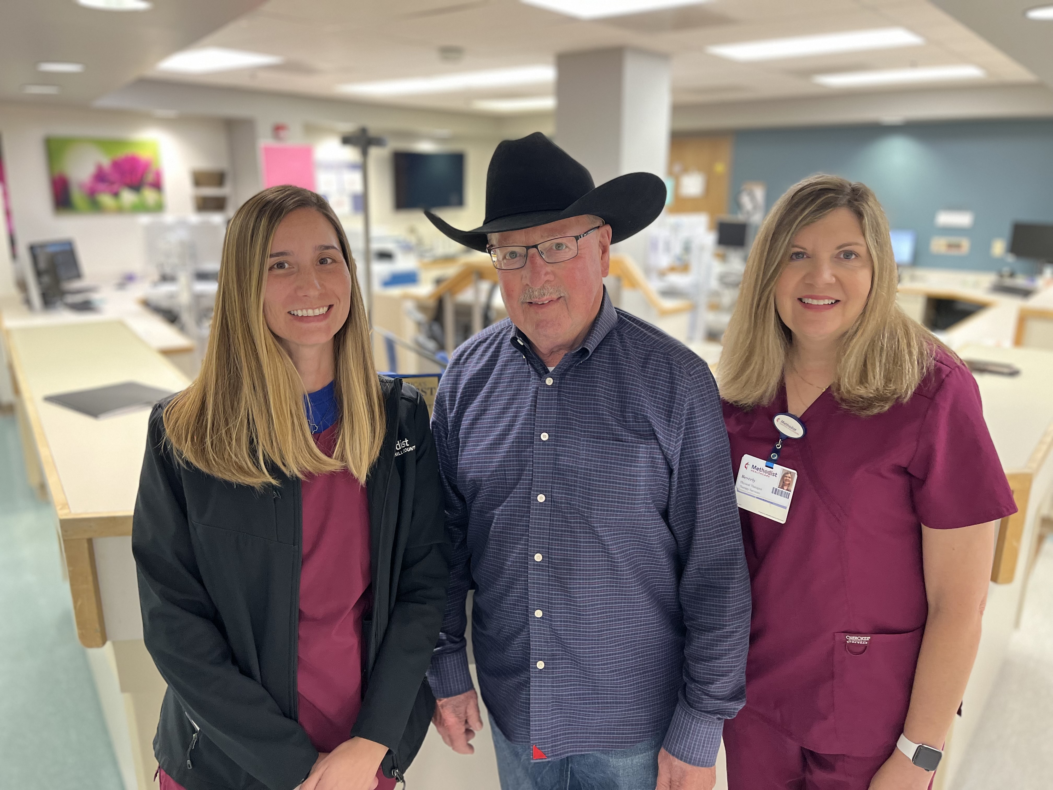Lester Meier and two nurses pose inside the hospital.