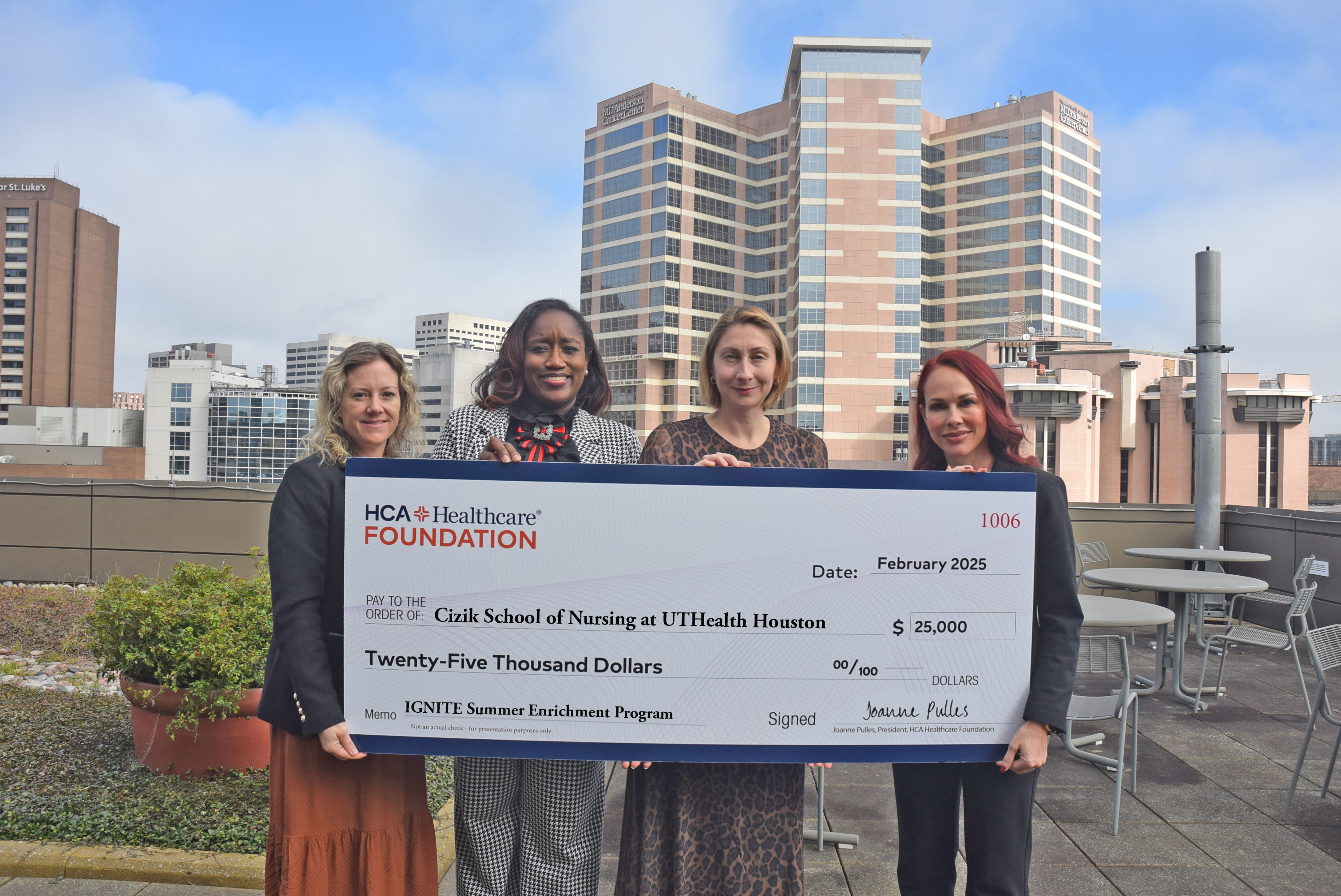 Four nurses pose holding grant check