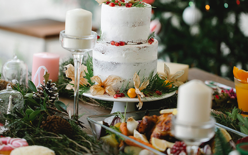 A table with greenery and a cake.