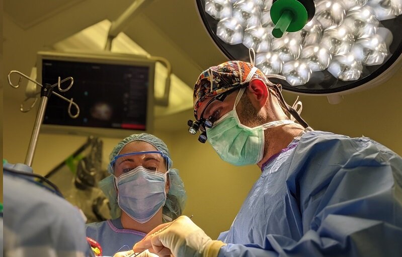 Vadim “Eddie” Tsvankin, M.D. in full surgical scrubs operating on a brain tumor.