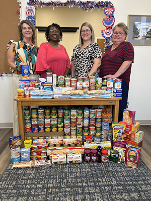 Colleton Medical Center's Health Information Management (HIM) office staff stand behind 70 lbs. of donations of non-perishable items for the blessing box.