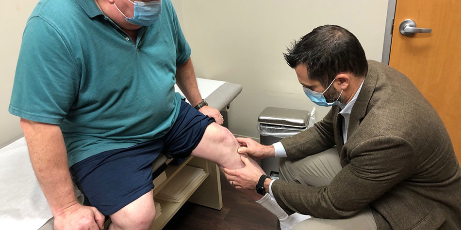 A doctor examining William Thompson's knee.