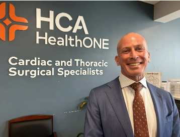 Cardiac and Thoracic Surgical Specialist logo with a man in a suit standing in front of it.