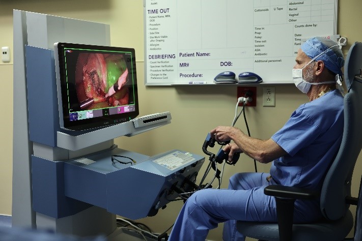 Dr. Steve Rothenberg sits at pediatric robotic surgical system.