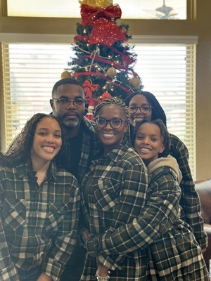 Hall family posing in front of a Christmas tree