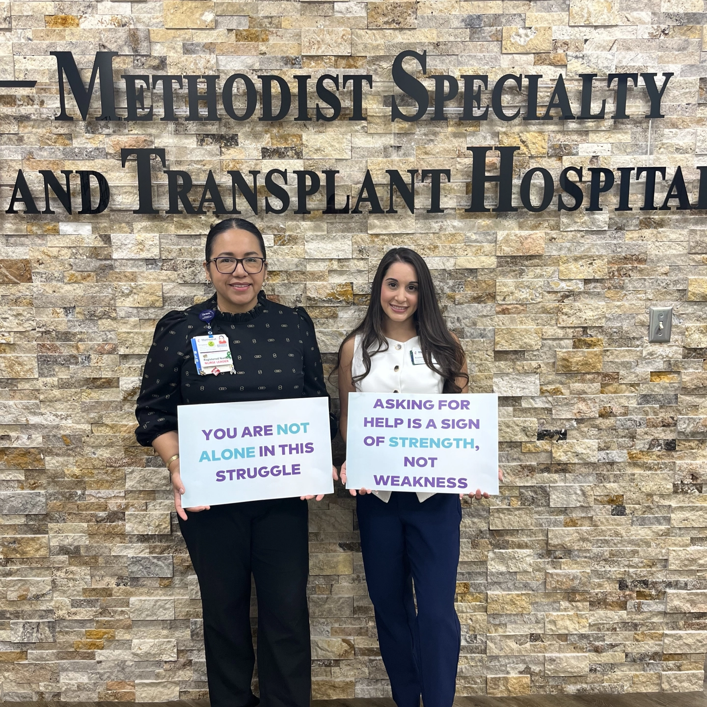 Methodist team members holds signs of encouragment on World Mental Health Day.