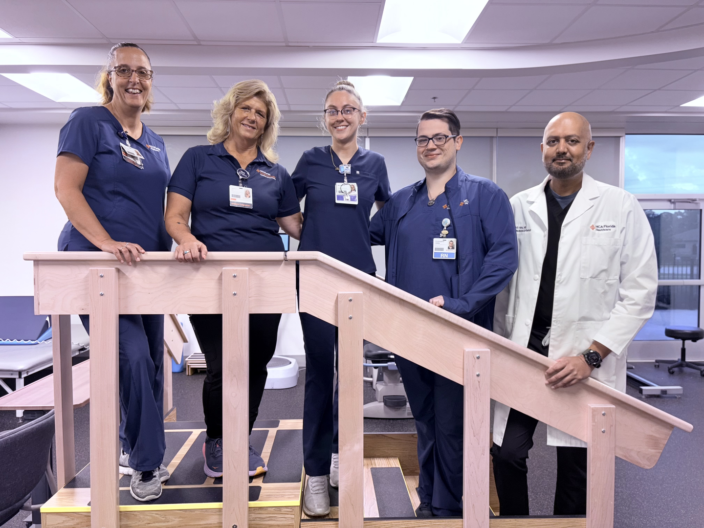 Mackenzie Beisner and nursing team posing on walking ramp in rehabilitation center.