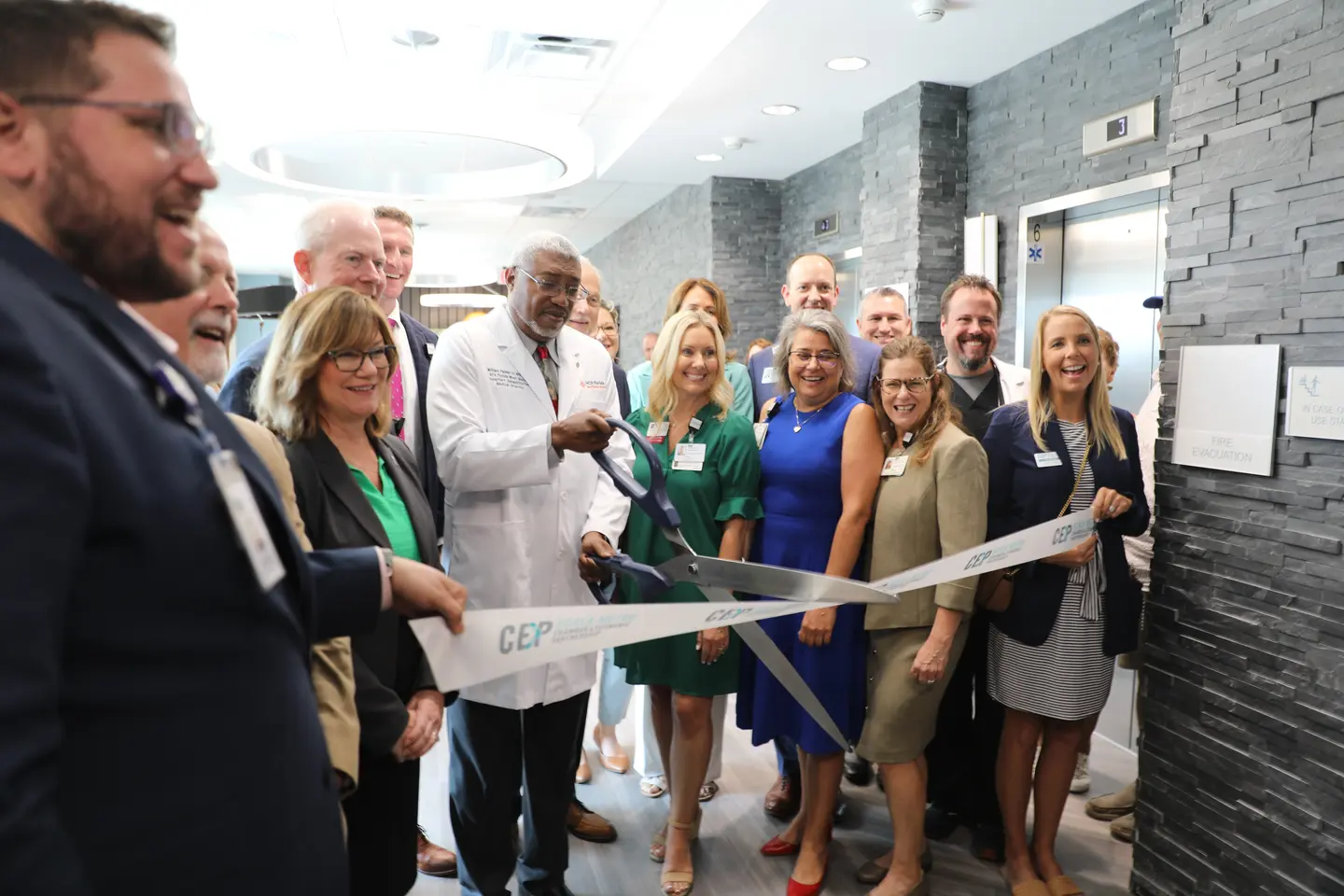 Hospital board and county officials celebrate by cutting the ribbon.