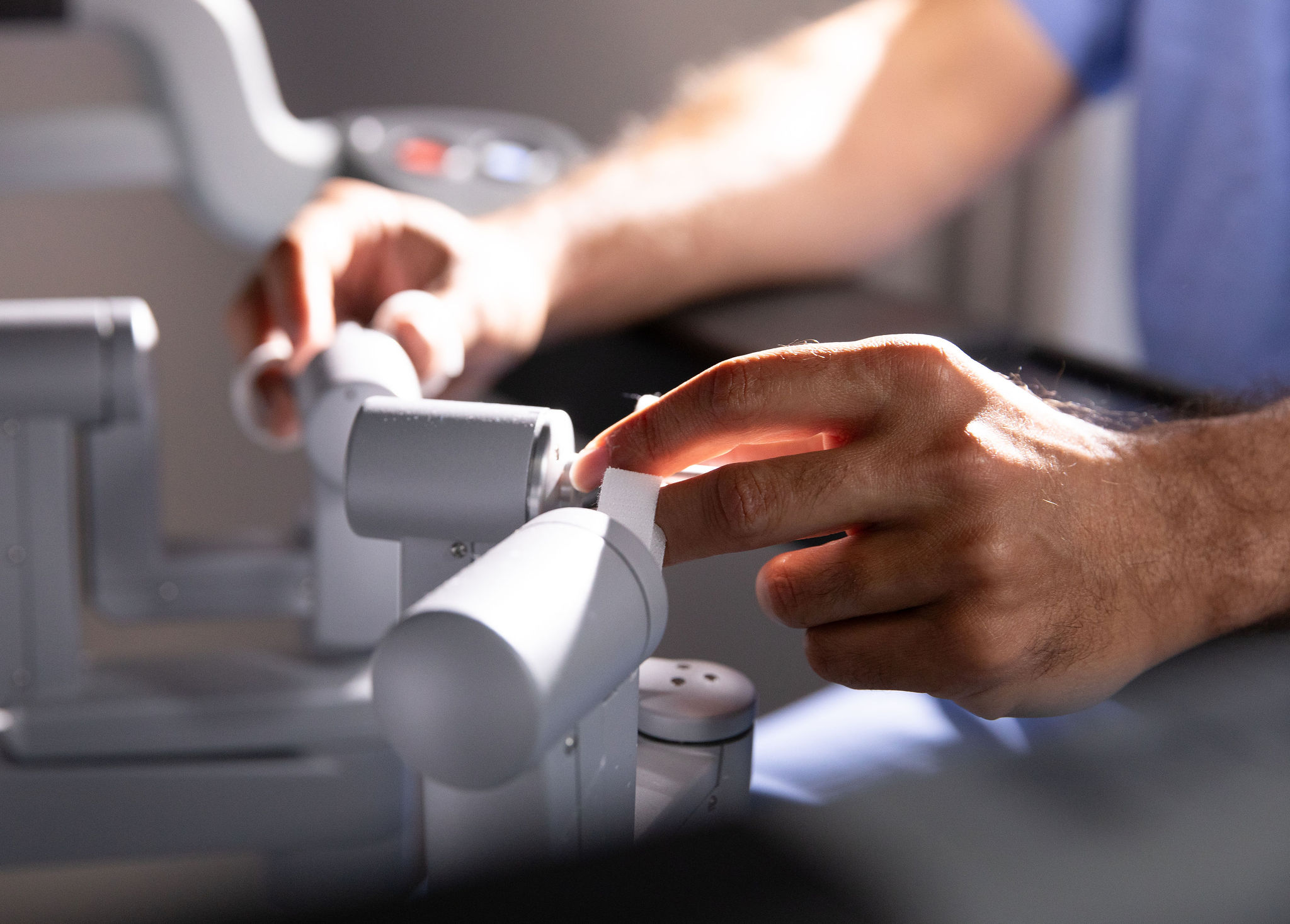 Dr. Farenjad's hands manipulating a robotic surgery device.