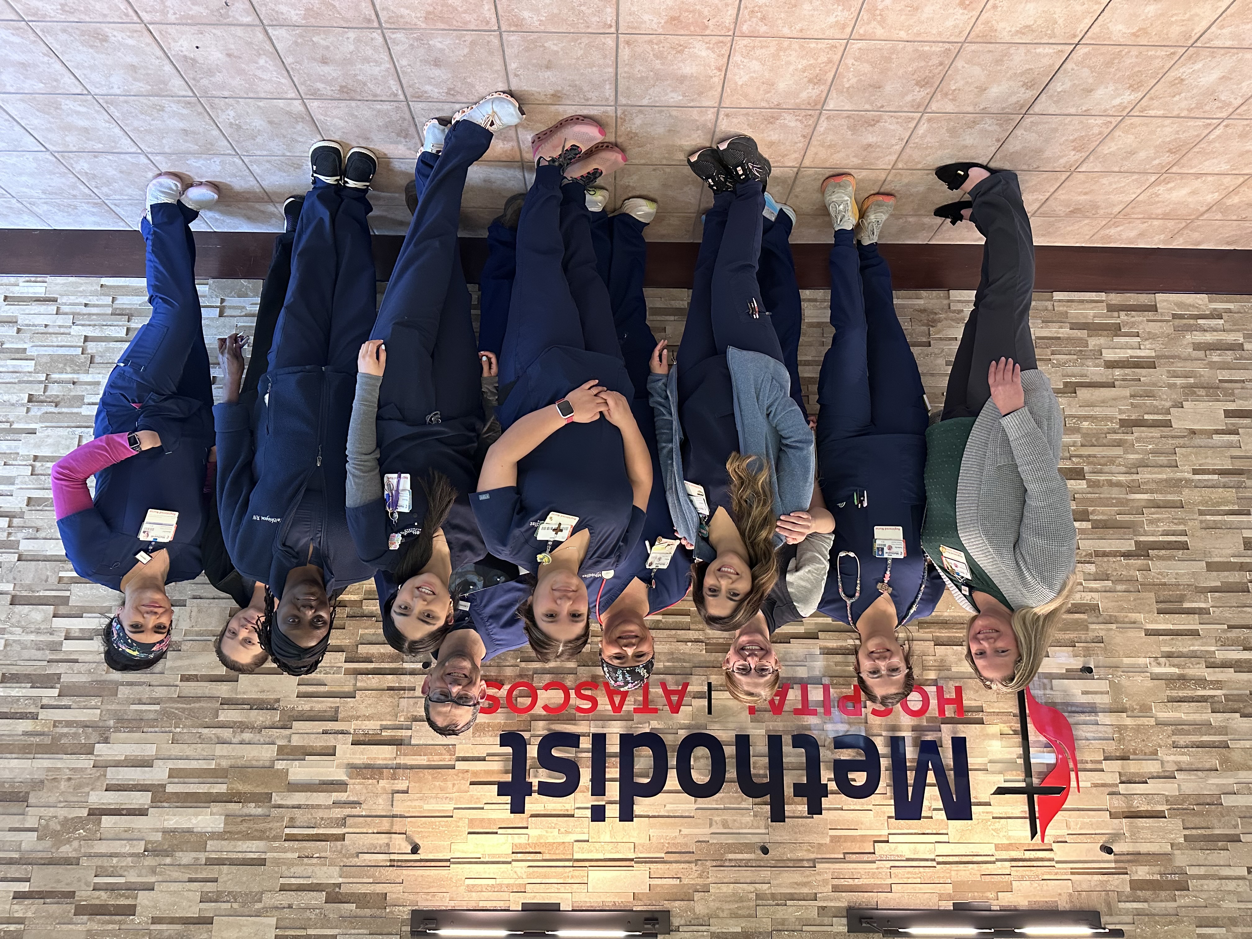 The Methodist Hospital Atascosa medical surgical telemetry unit poses for a group photo in front of the hospital logo.