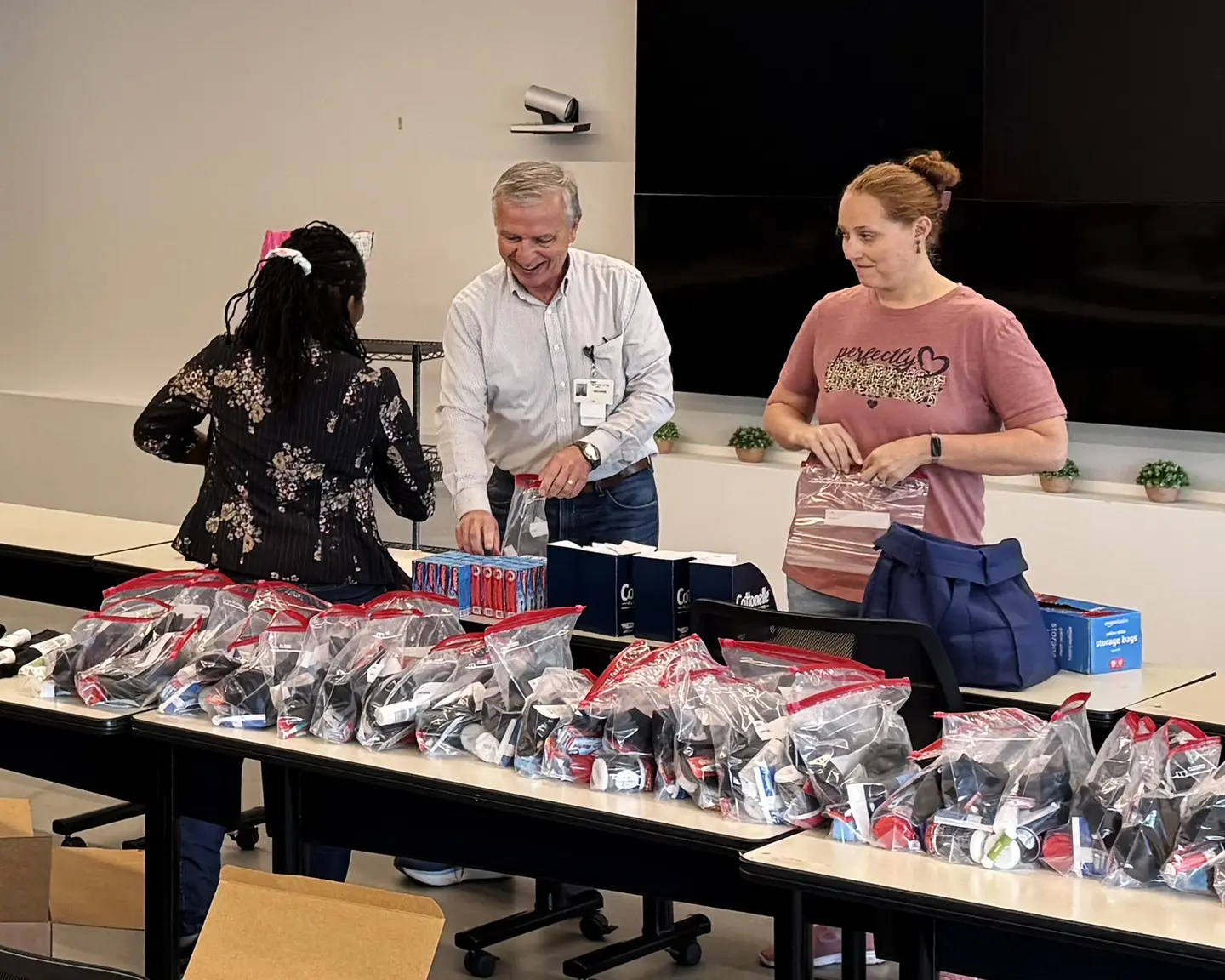 Three colleagues preparing care packages for delivery.