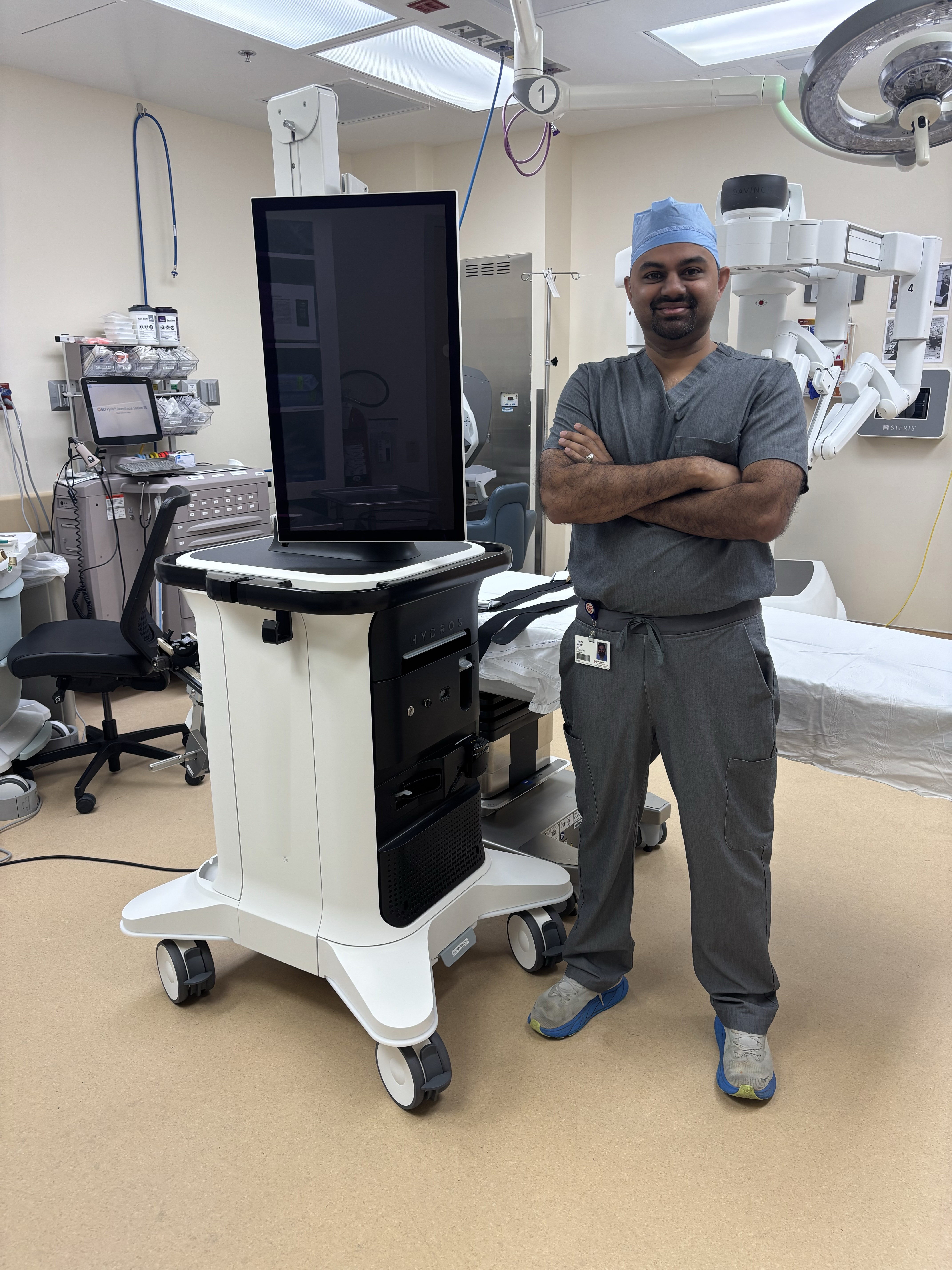 Dr. Rishi Modh stands proudly next to aquablation machine.