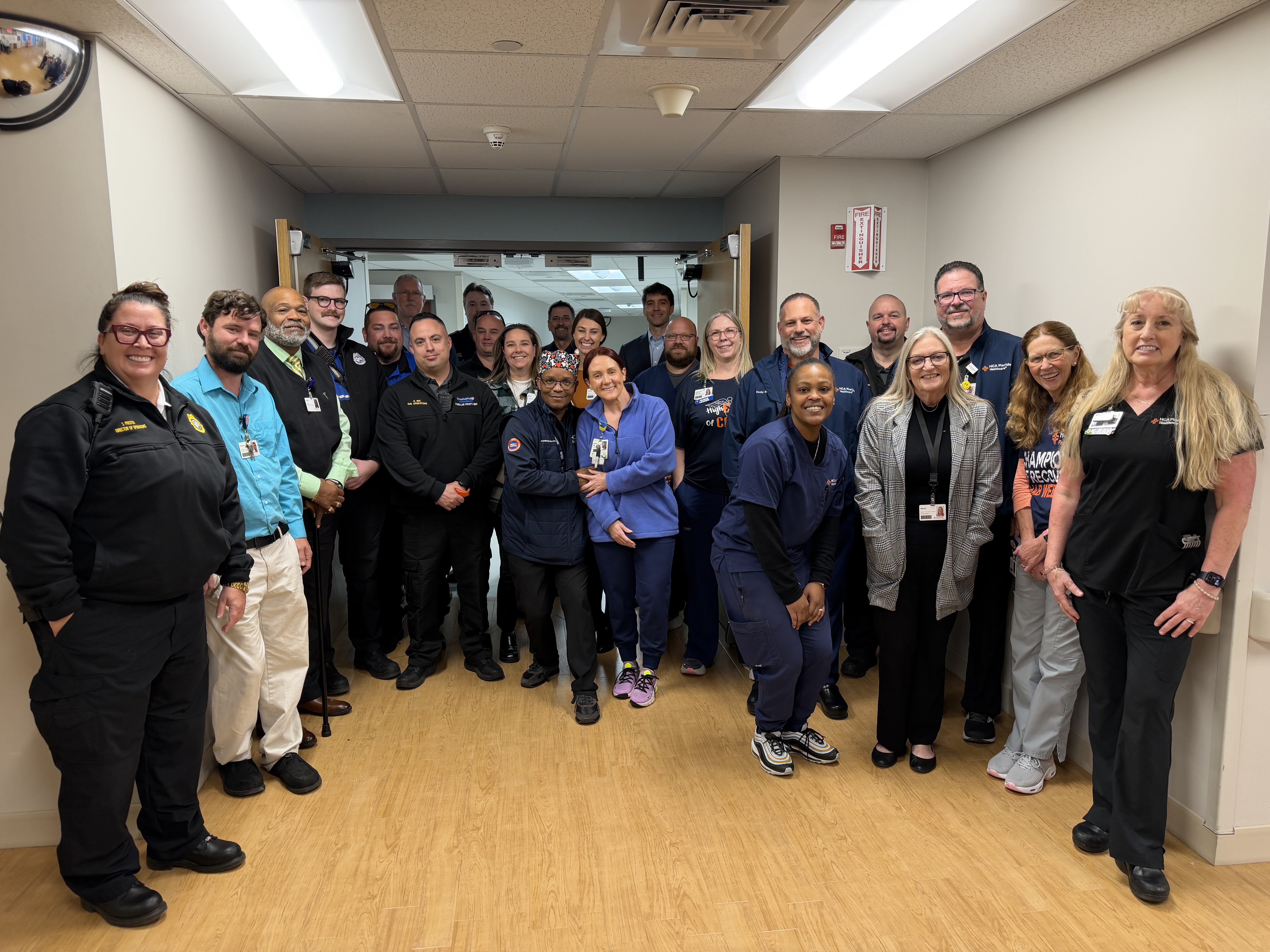 Members of Pasadena hospital stand, smile and pose for a photo.  