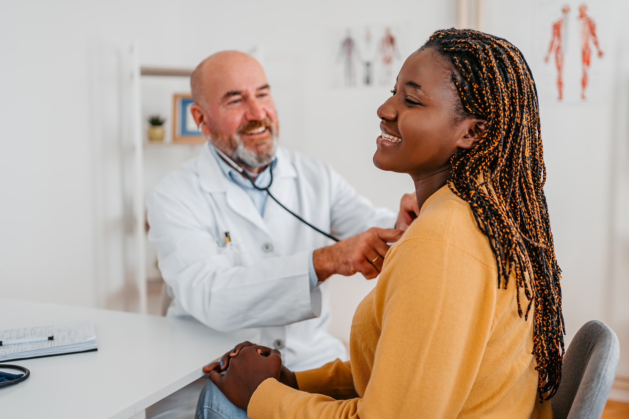 A doctor is using a stethoscope to listen to a patients heart.