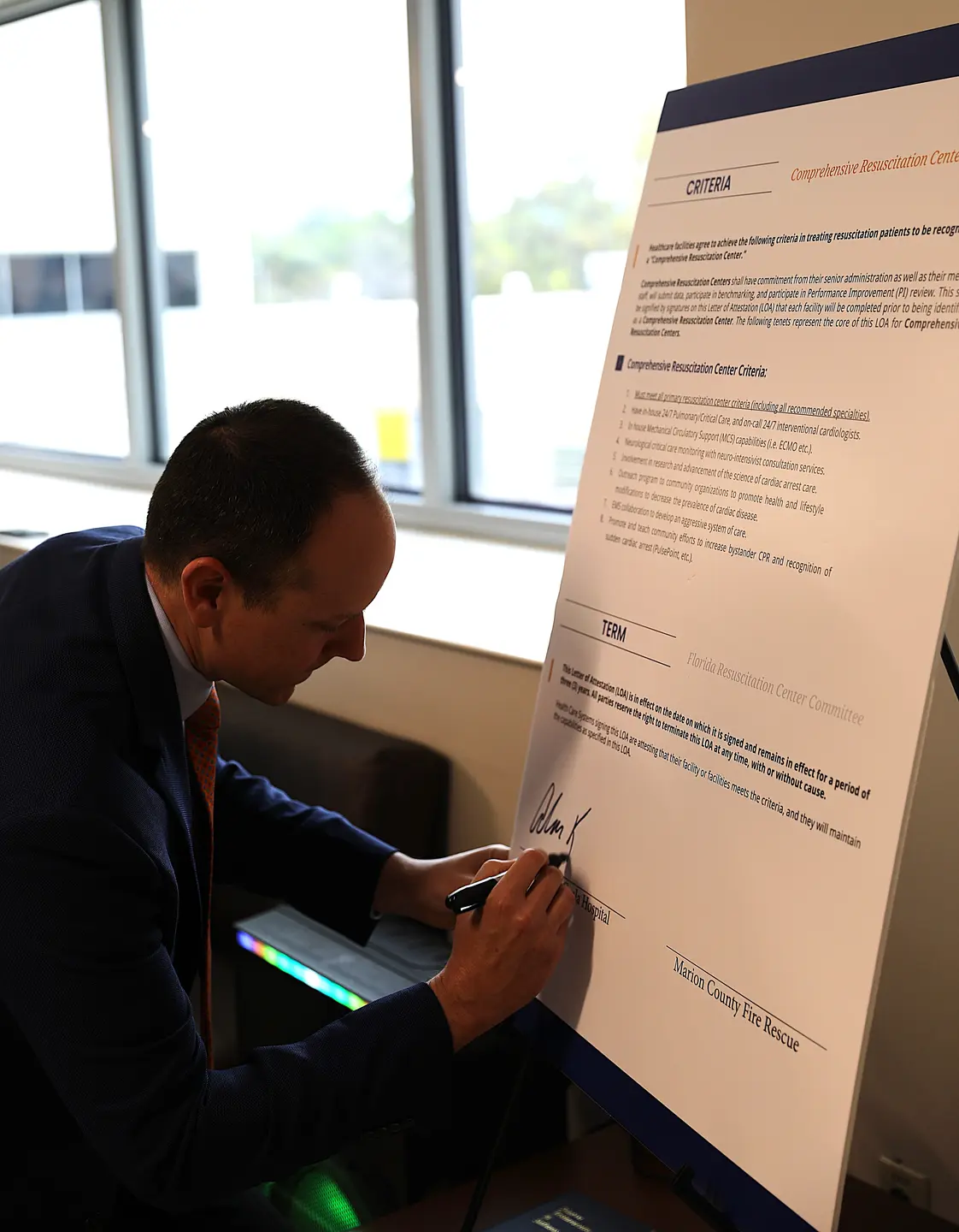 A man signing a poster
