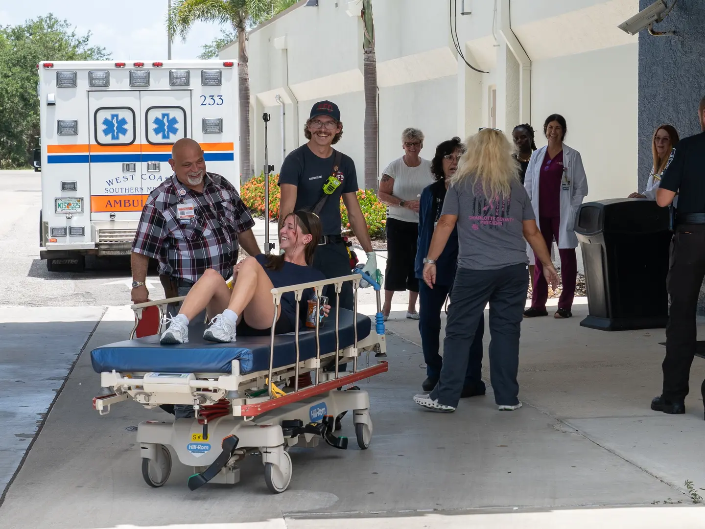 mock patient smiles on gurney with first responders and hospital staff during triage phase of emergency drill