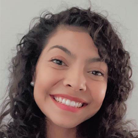 Linda Clavijo smiling and wearing pearl earrings.