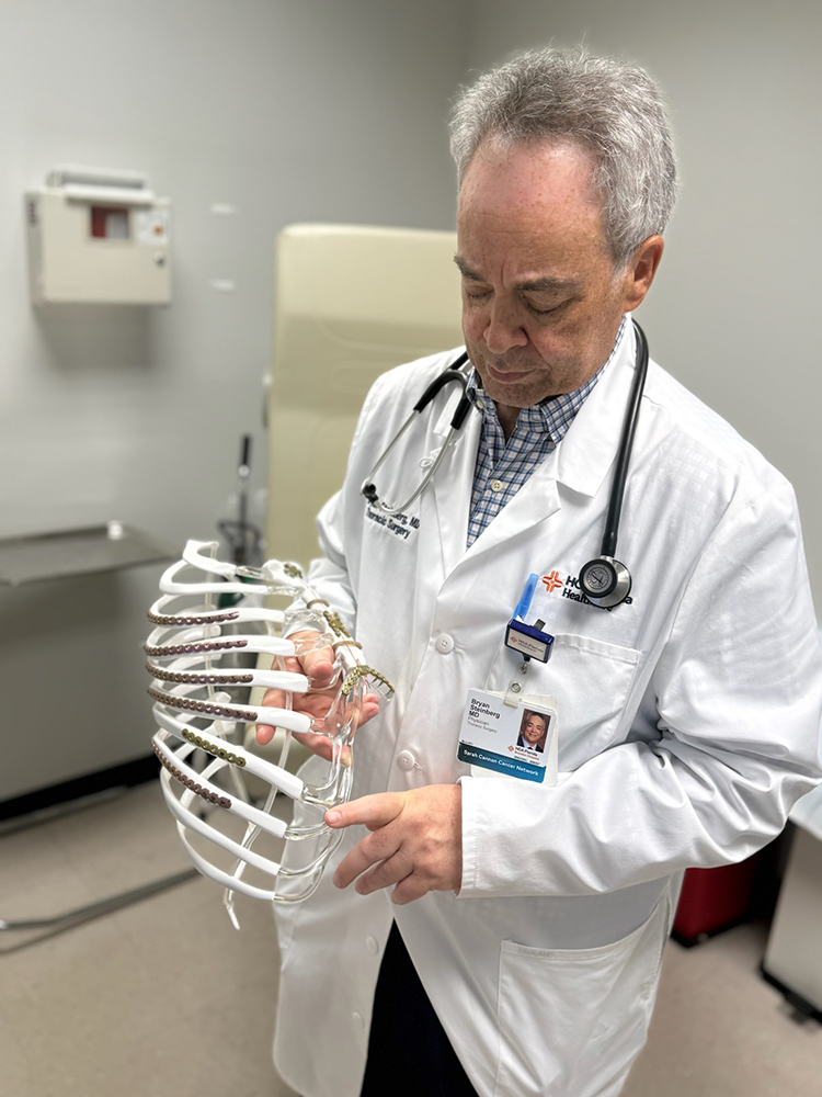 Dr. Bryan Steinberg, cardiothoracic surgeon at HCA Florida Brandon Hospital points to rib model.