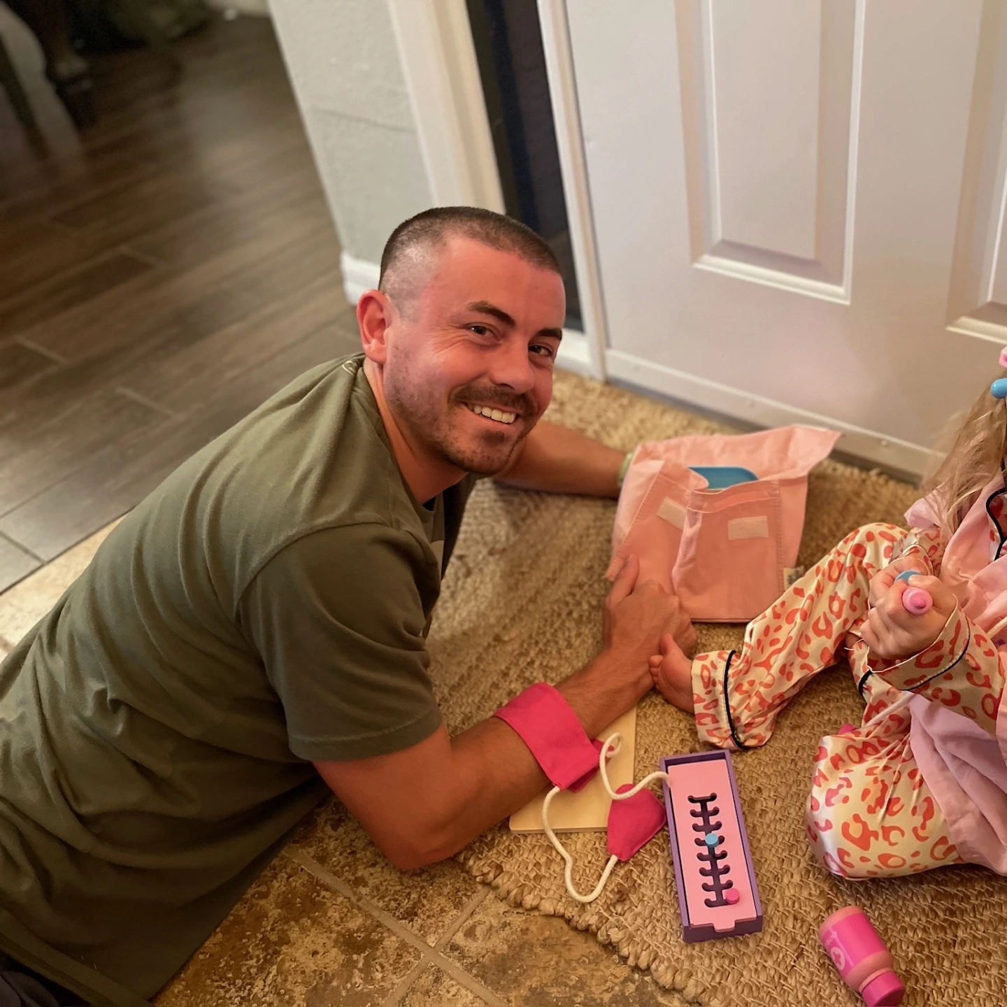 Nic lying on the floor with Indie who's dressed up as a doctor.