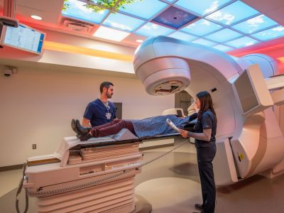 A virtual rendering of clinic staff treating a patient with a linear accelerator in the Oncology suite at Portsmouth Regional Hospital.