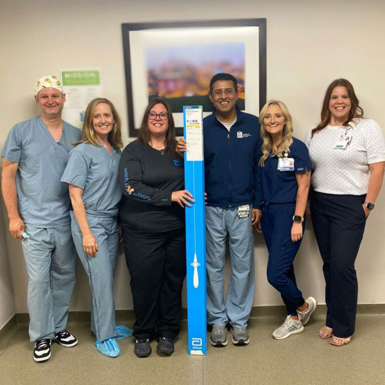 The cardiac surgery team that was taking care of Zona, holding a duplicate of the catheter used during the procedure.