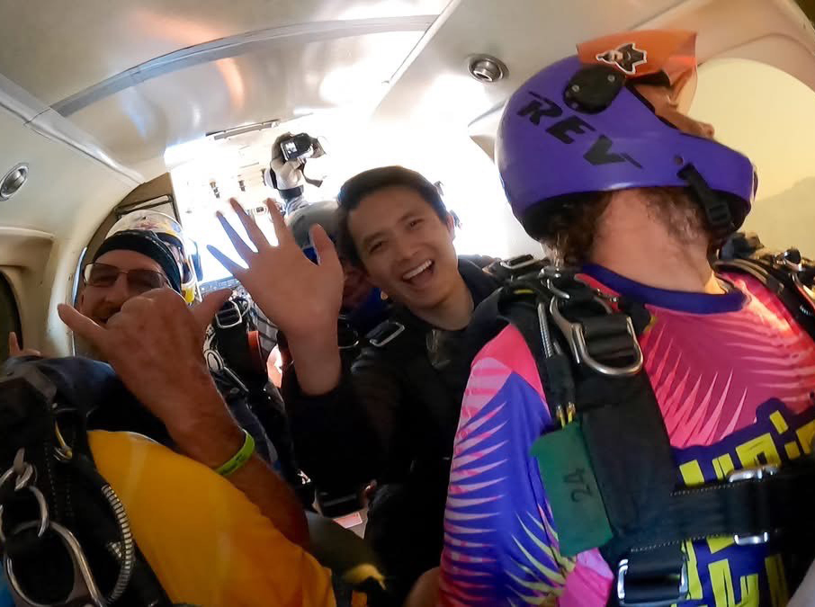 Dr. Tran in the airplane with other jumpers preparing to jump