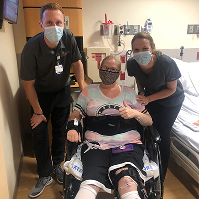 Patient Heather Twedt gives a thumbs-up with hospital staff.