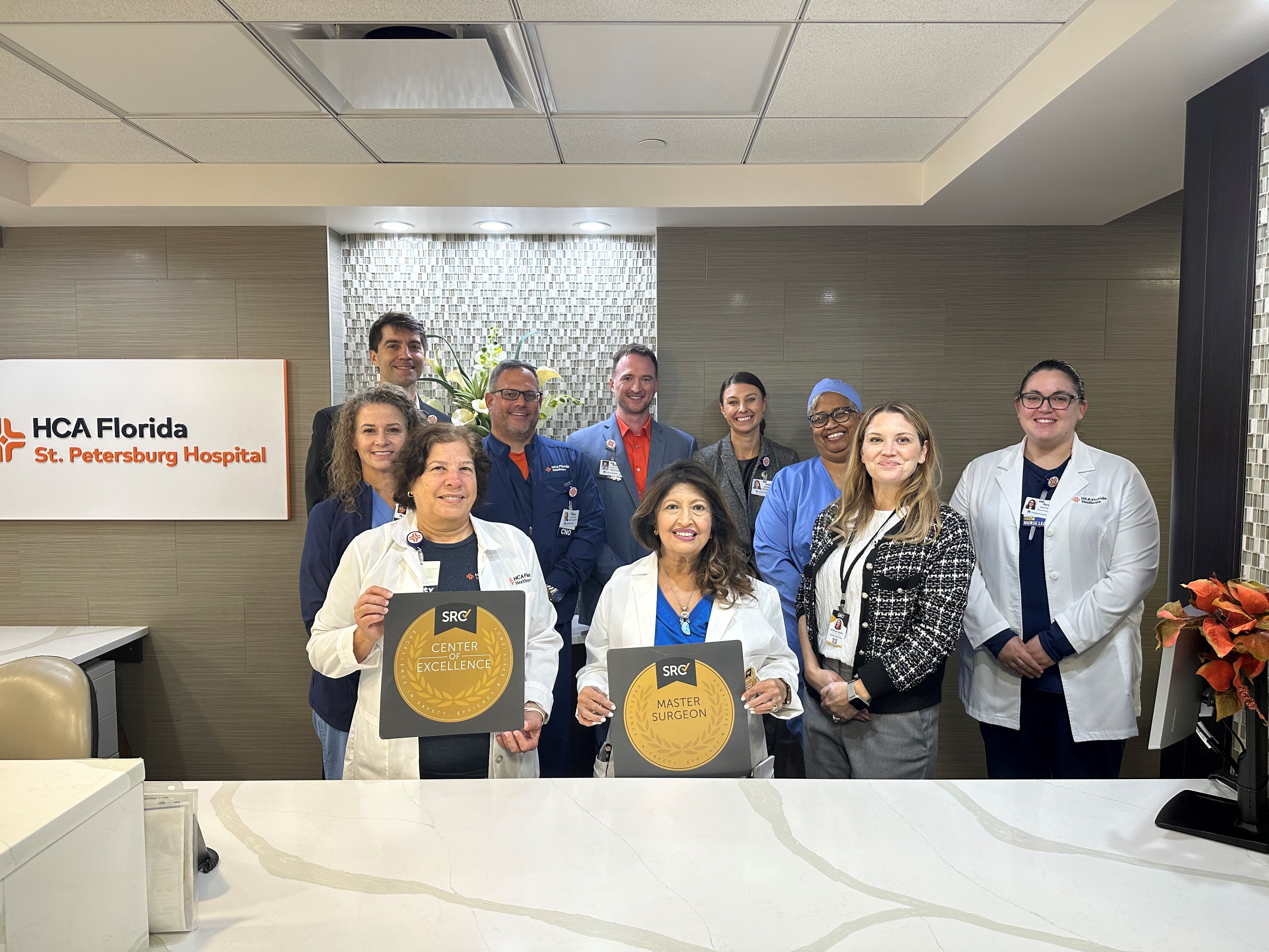 Robotic surgery team posing with award plaques.