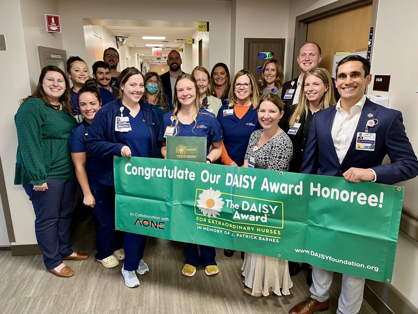 HealtONE Swedish physical therapy and rehabilitation team and Sara Velez holding a DAISY award banner.