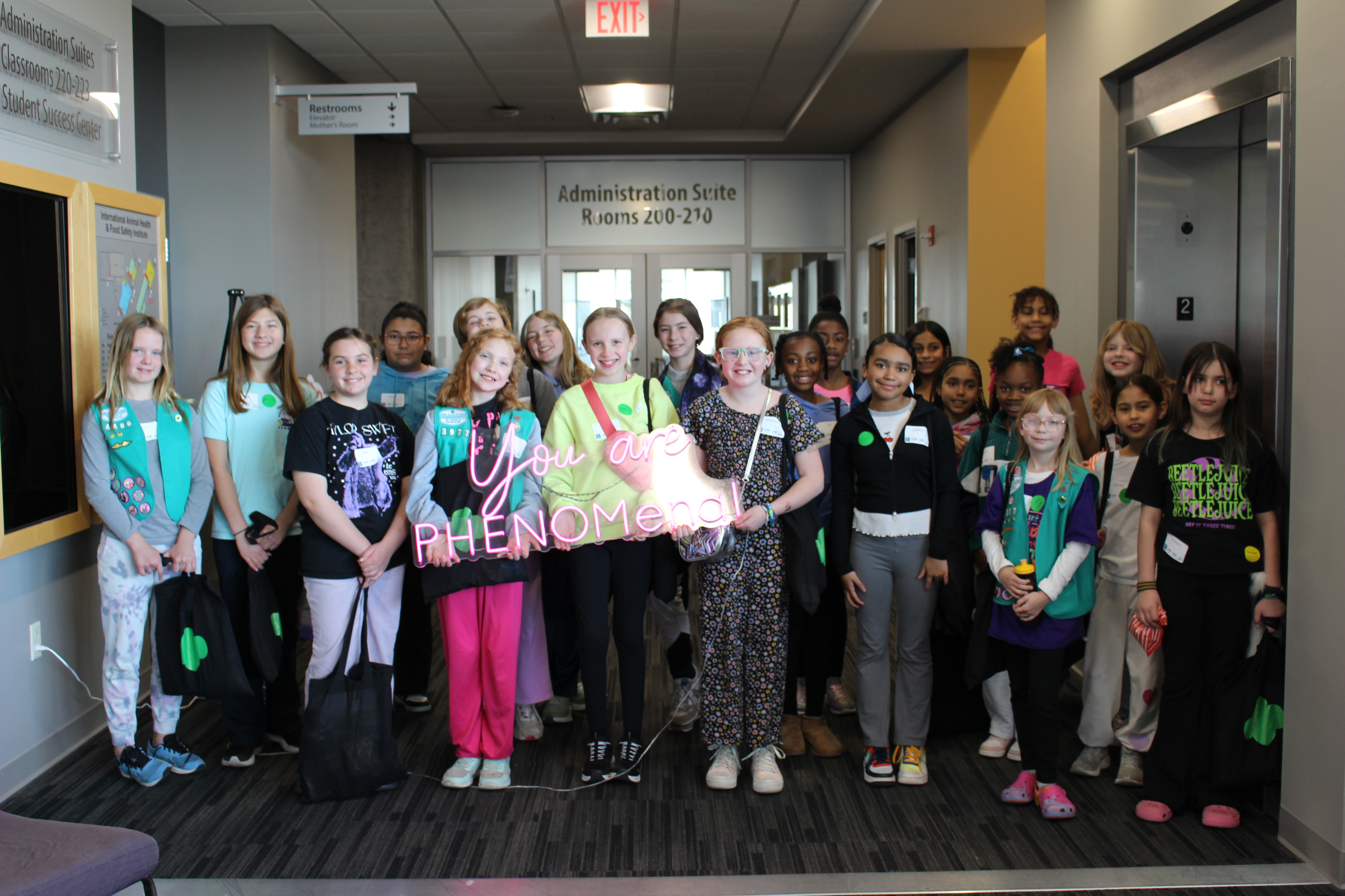 Girls holding a you are phenomenal sign after a mental health seminar.