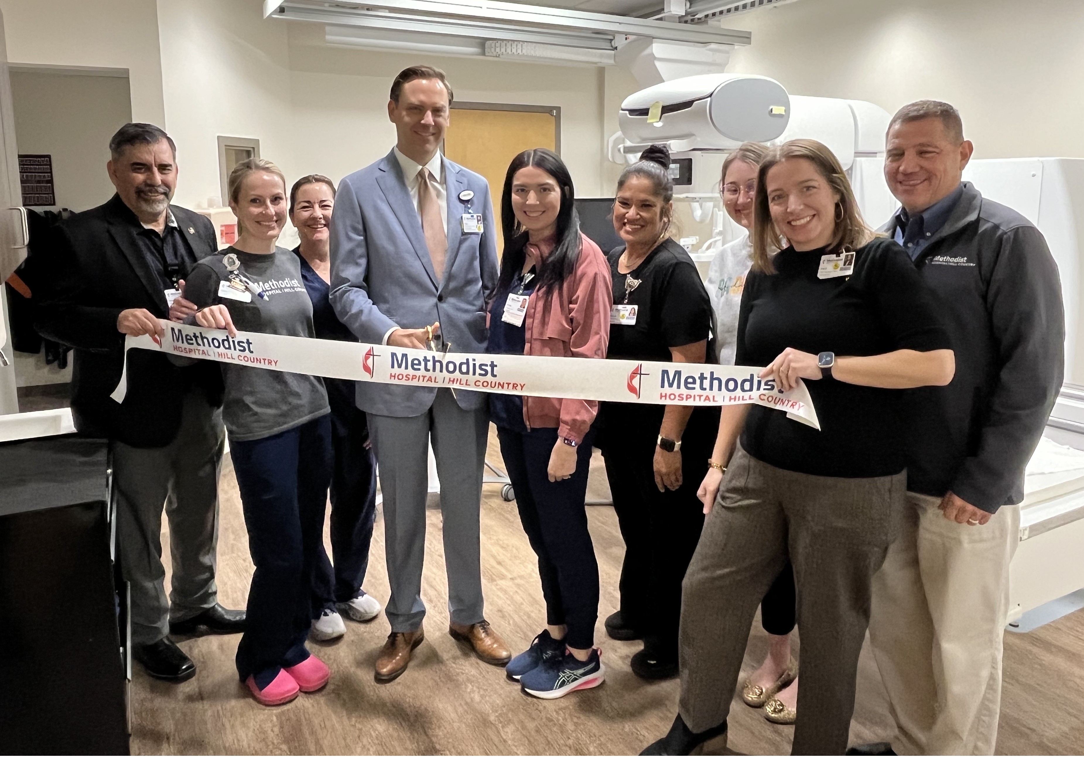 Hospital employees cutting a ribbon in celebration of a renovation.