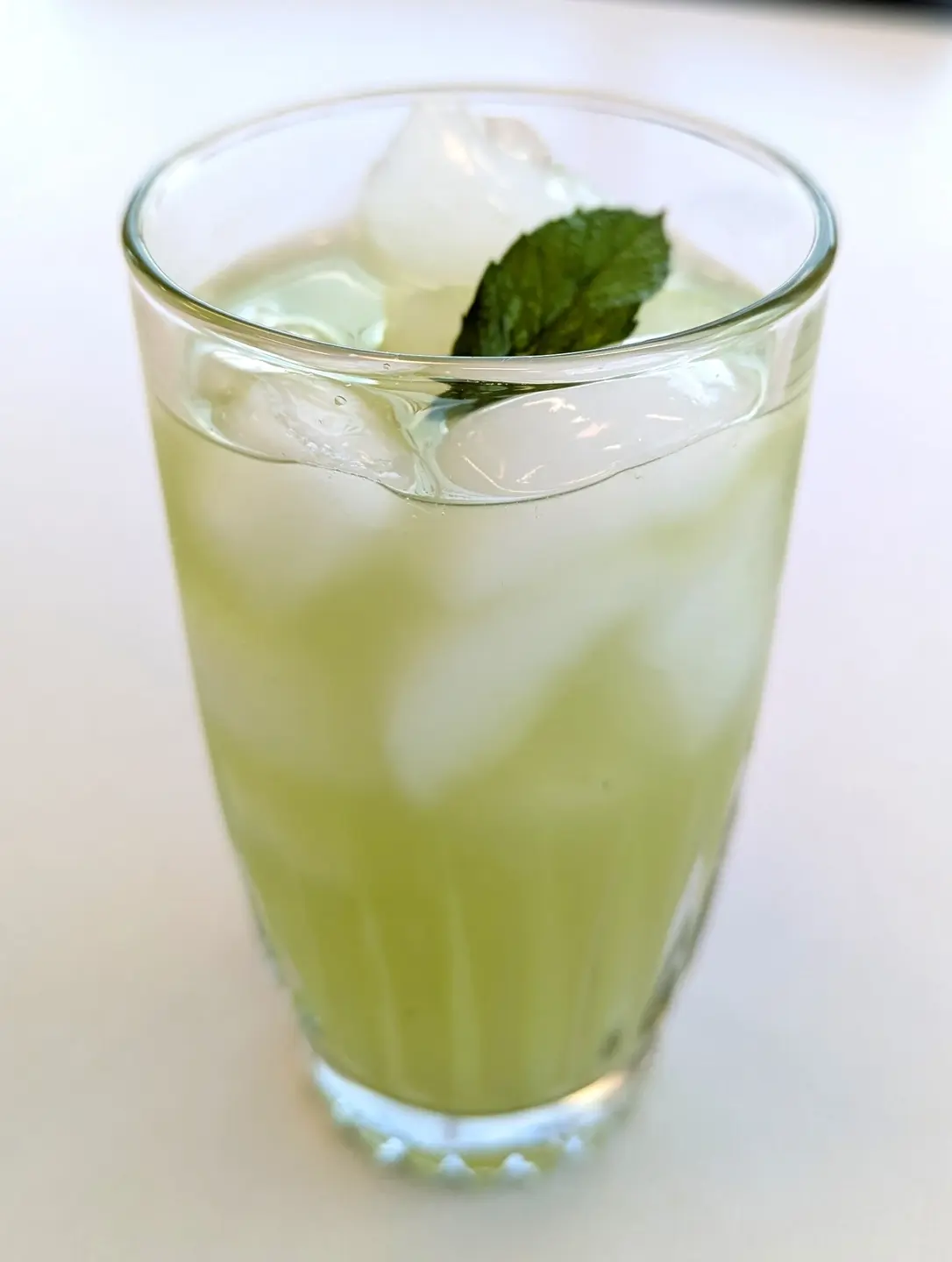Cucumber lime cooler with a mint leaf for a garnish.