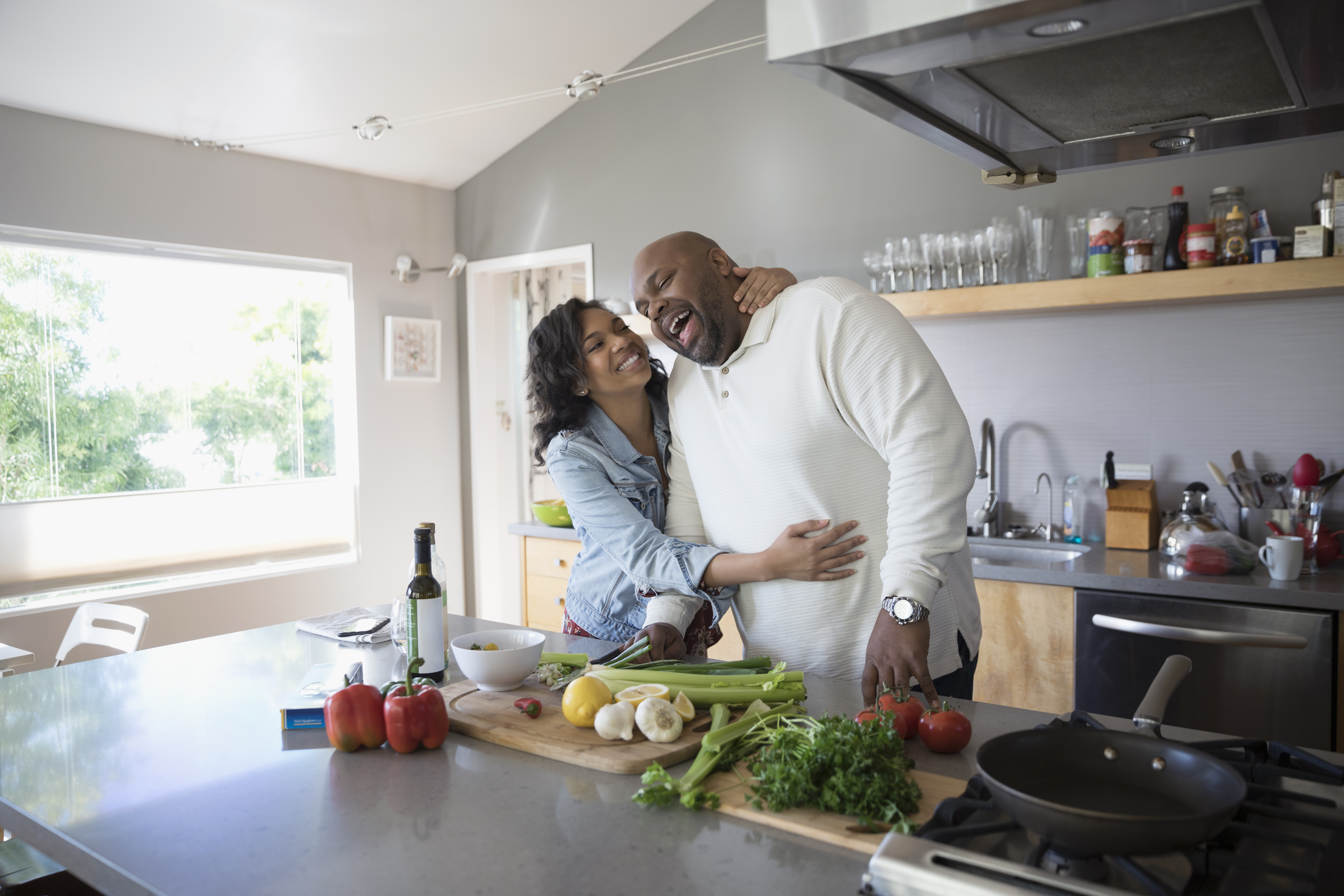 Couple laugh as they cook dinner