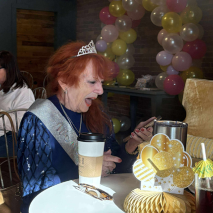 Photo of Lucy Nelson on her 90th birthday, watching a video message from her former nurse.